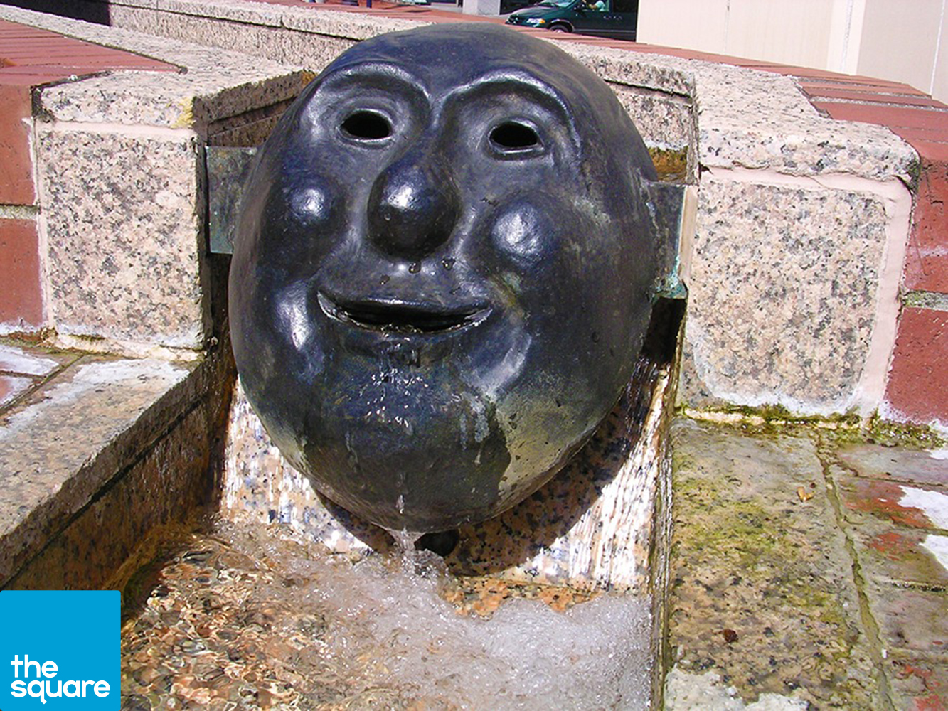 Five bronze cast masks, designed by Will Martin, reside in the water trough surrounding the back patio of Starbucks.
